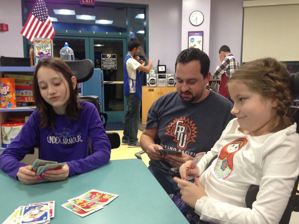 Playing card in Child Life with violinist in the background.